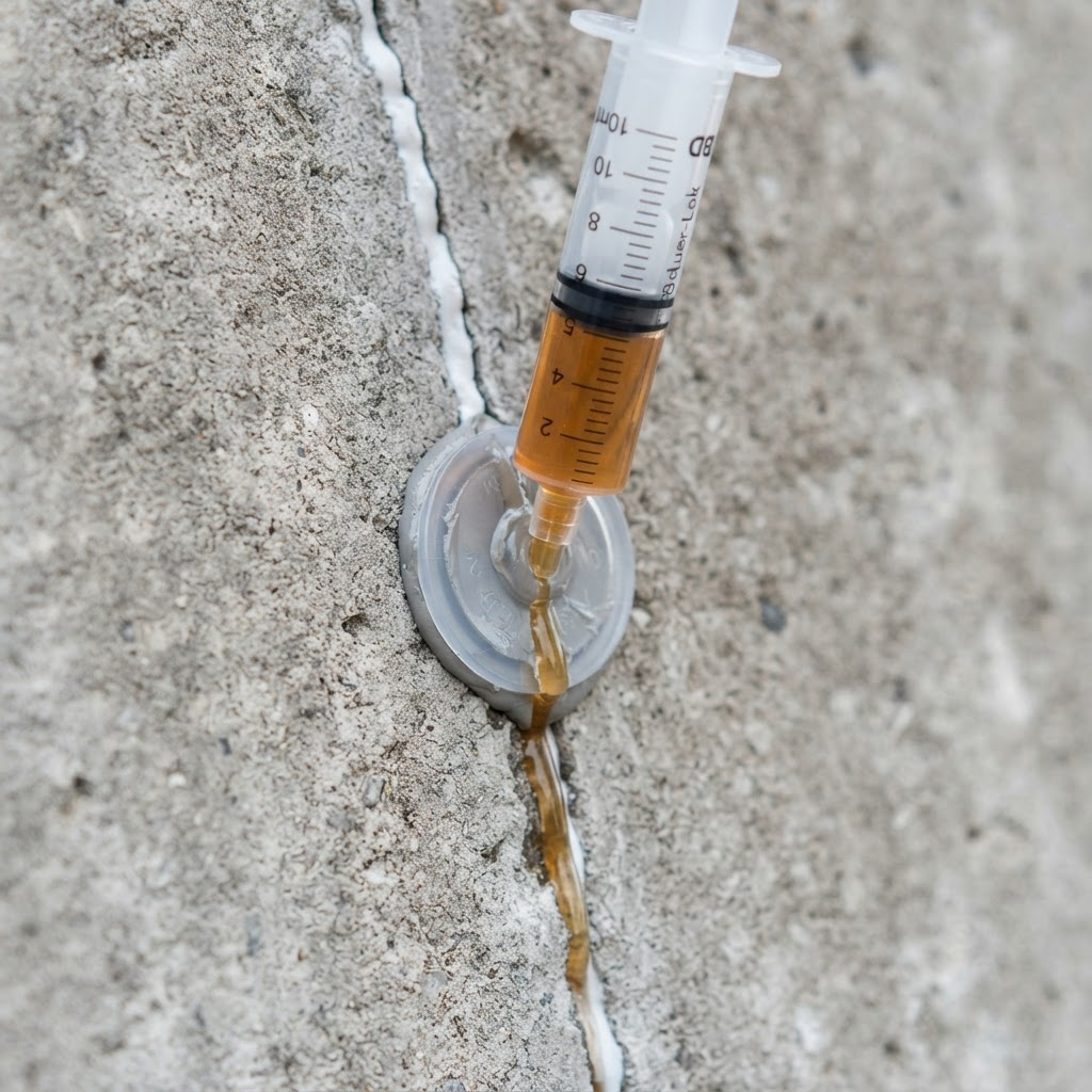 Epoxy injection resin being injected into a concrete crack
